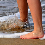 person barefoot at ocean shore